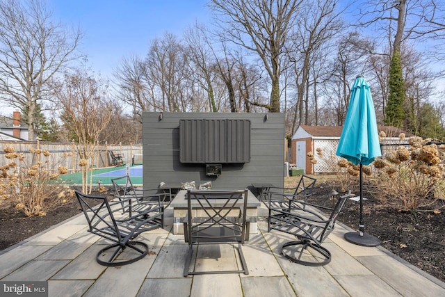 view of patio featuring outdoor dining area, an outdoor structure, and fence