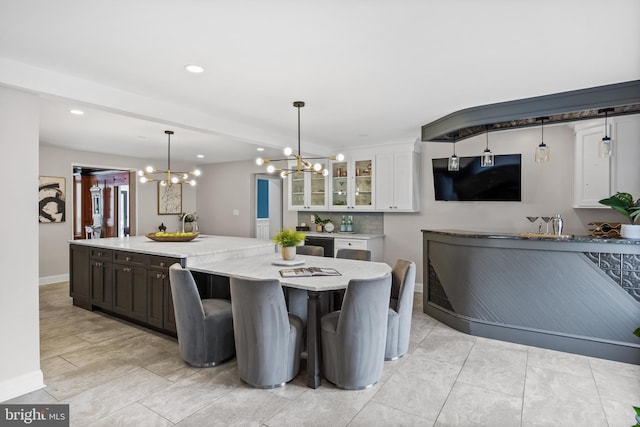 dining area with a chandelier, recessed lighting, and baseboards