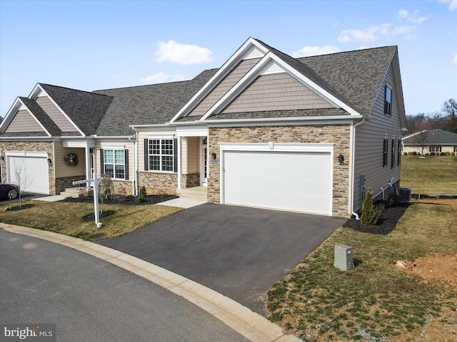 craftsman house with stone siding, cooling unit, and driveway