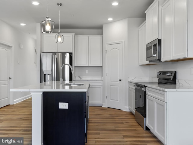 kitchen featuring a center island with sink, recessed lighting, wood finished floors, stainless steel appliances, and a sink