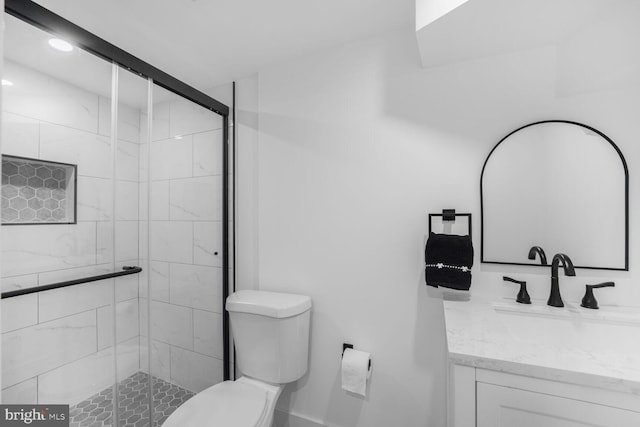 bathroom with a stall shower, toilet, and vanity