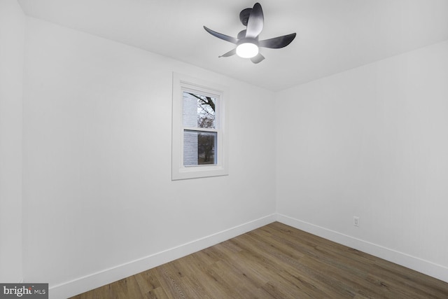 empty room featuring ceiling fan, baseboards, and wood finished floors