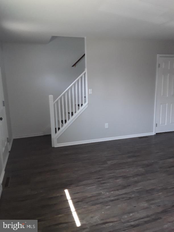 interior space featuring stairway, baseboards, and dark wood-style flooring