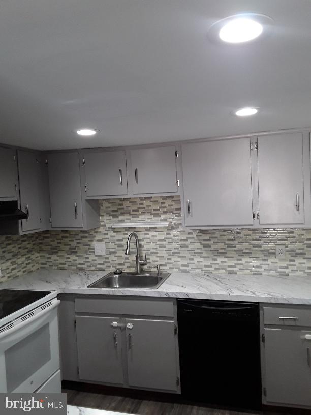 kitchen with a sink, black dishwasher, gray cabinetry, and white electric range oven