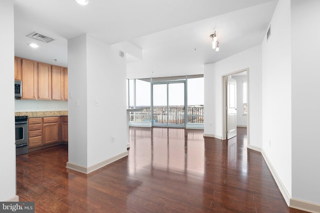 kitchen with stainless steel microwave, visible vents, dark wood-type flooring, recessed lighting, and range with electric stovetop