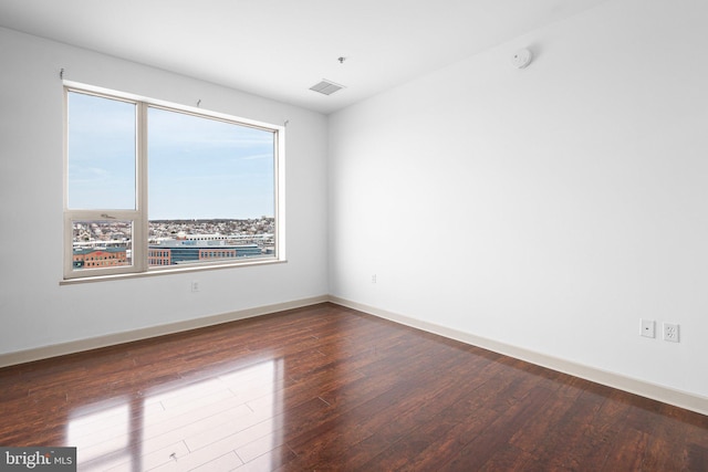 empty room with baseboards and hardwood / wood-style flooring