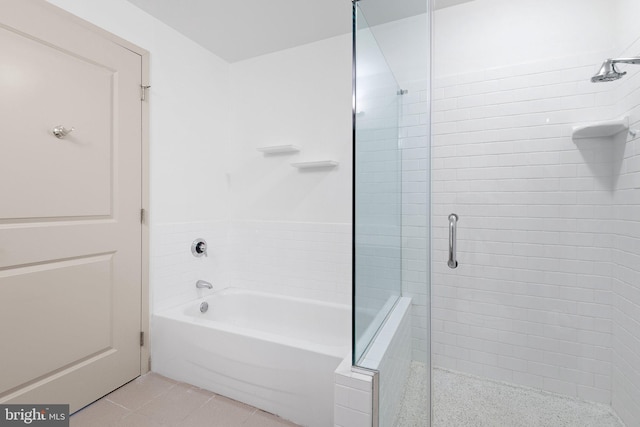 full bathroom with tile patterned flooring, a tub to relax in, and tiled shower