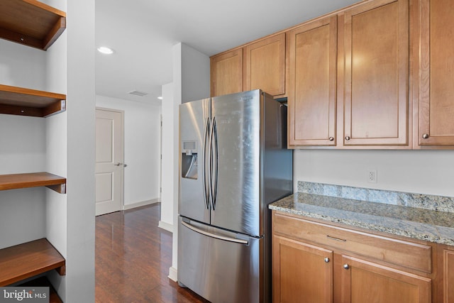 kitchen with visible vents, stainless steel refrigerator with ice dispenser, open shelves, light stone counters, and dark wood finished floors