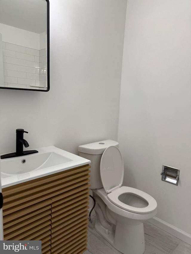 bathroom with vanity, toilet, and baseboards