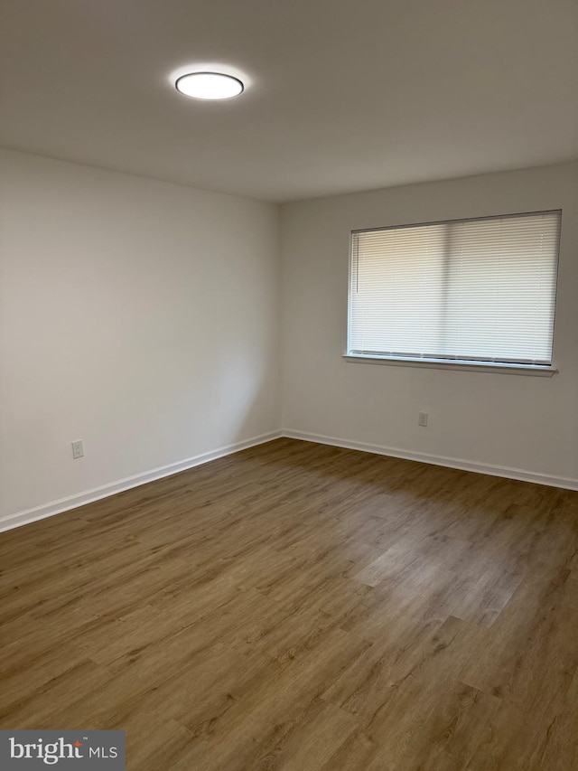 empty room with baseboards and wood finished floors