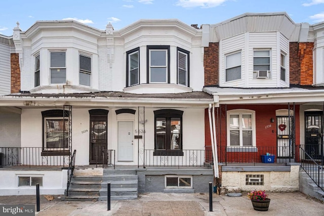 multi unit property featuring cooling unit, brick siding, and a porch