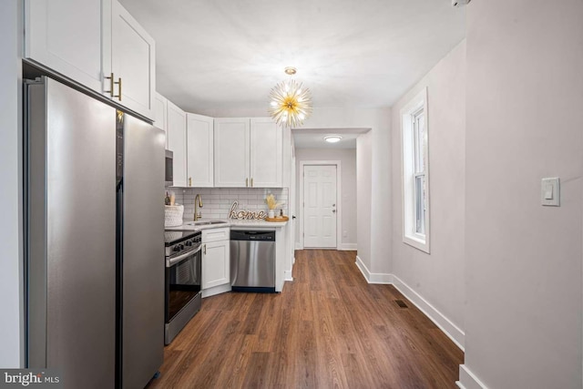 kitchen featuring a sink, stainless steel appliances, light countertops, white cabinets, and tasteful backsplash