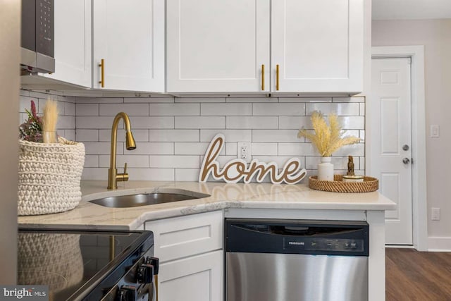 kitchen with a sink, light stone counters, range with electric stovetop, stainless steel dishwasher, and white cabinets