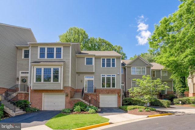 view of property featuring an attached garage, driveway, and stairs
