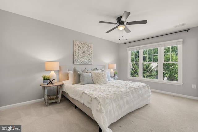 bedroom with light colored carpet, baseboards, and a ceiling fan