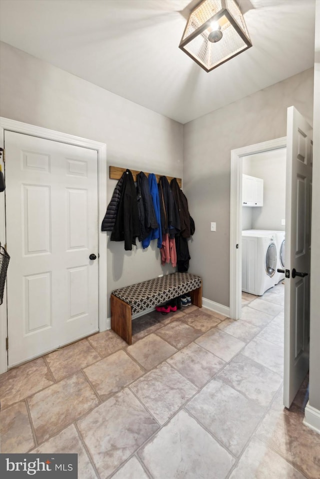 mudroom with baseboards and washing machine and dryer