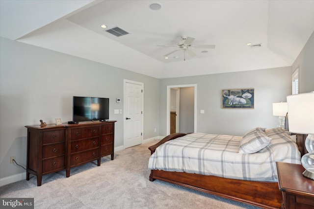 bedroom with a tray ceiling, visible vents, baseboards, and carpet