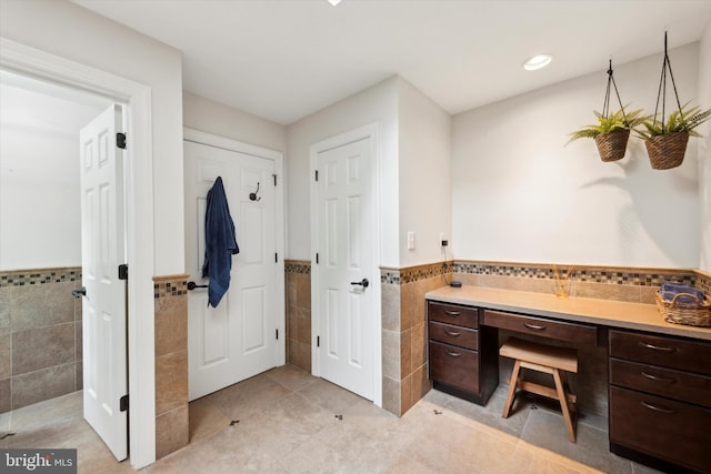 bathroom with tile patterned flooring, tile walls, recessed lighting, and wainscoting