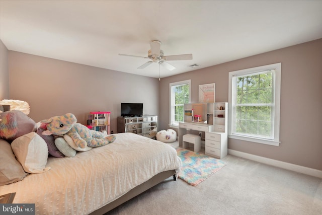 bedroom featuring visible vents, baseboards, light colored carpet, and a ceiling fan