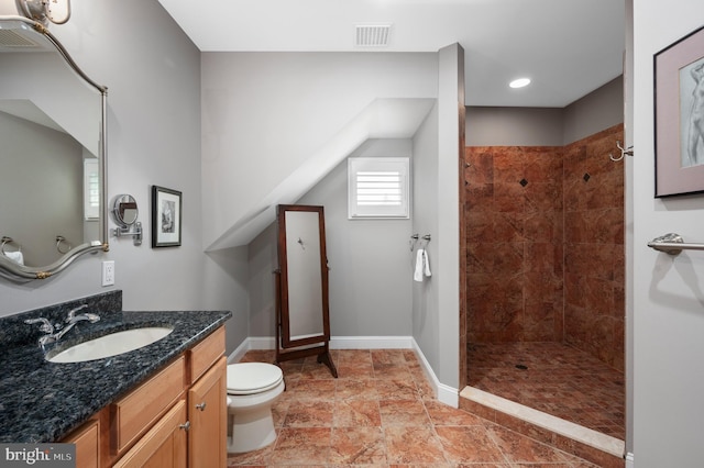 bathroom with visible vents, toilet, baseboards, tiled shower, and vanity