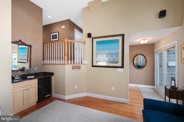 interior space with baseboards, wine cooler, and light wood finished floors