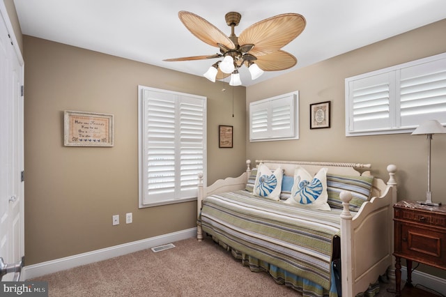 carpeted bedroom with visible vents, ceiling fan, and baseboards