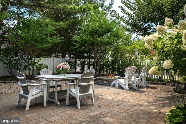 view of patio featuring a fire pit and fence