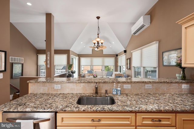 kitchen with visible vents, lofted ceiling, a sink, an AC wall unit, and a notable chandelier