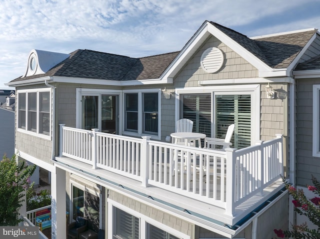 back of property with a shingled roof