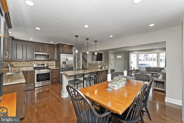 dining space with recessed lighting, dark wood finished floors, and baseboards