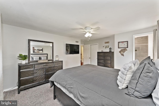 carpeted bedroom with ensuite bath, ceiling fan, visible vents, and a closet
