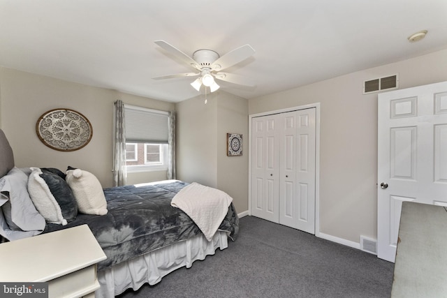 bedroom featuring dark colored carpet, visible vents, a ceiling fan, and a closet