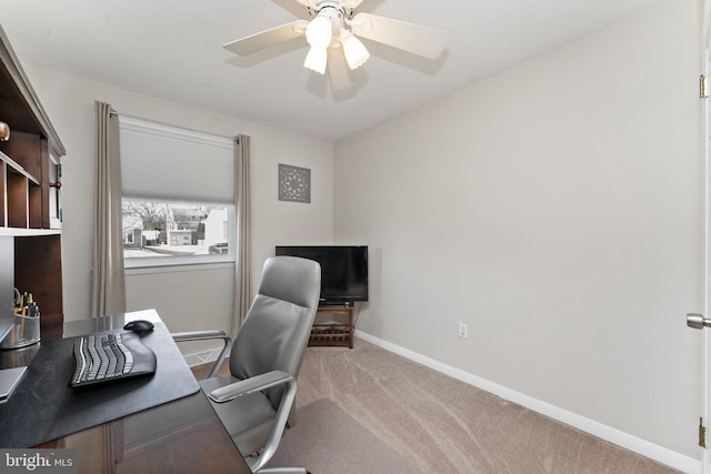 office space featuring baseboards, ceiling fan, and carpet floors