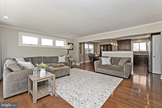 living area with dark wood finished floors, baseboards, ornamental molding, and recessed lighting