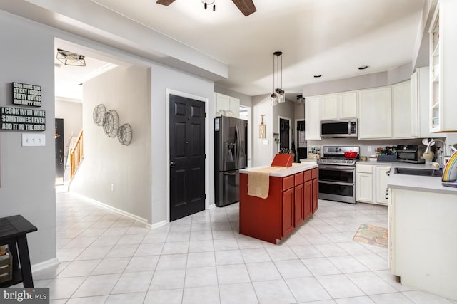 kitchen featuring a ceiling fan, a sink, appliances with stainless steel finishes, white cabinets, and light countertops