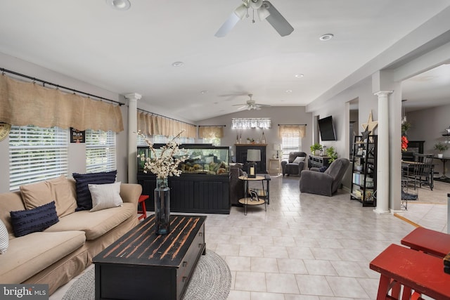 living room with light tile patterned flooring, vaulted ceiling, a ceiling fan, and ornate columns