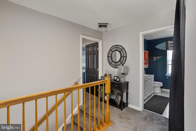 hallway with light colored carpet and baseboards