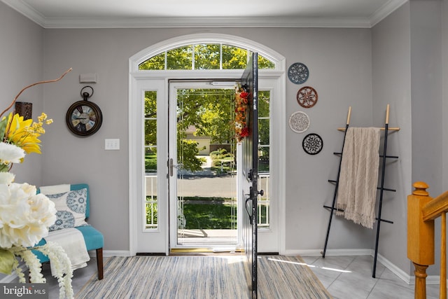 tiled foyer with crown molding and baseboards