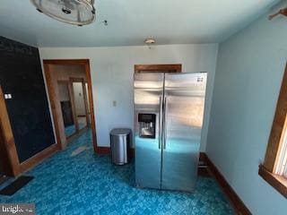 kitchen with baseboards and stainless steel refrigerator with ice dispenser