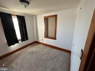 unfurnished room featuring baseboards and carpet floors