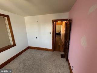 carpeted empty room with baseboards