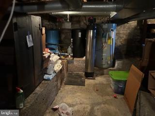 unfinished below grade area featuring water heater