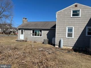 back of house featuring a chimney