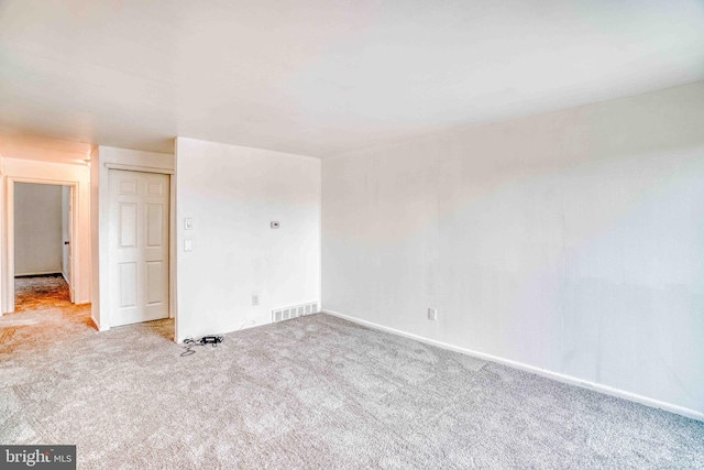 carpeted empty room with visible vents and baseboards