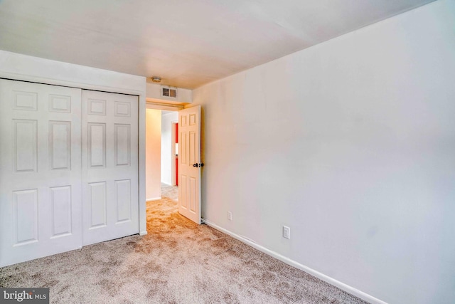 unfurnished bedroom with visible vents, baseboards, a closet, and carpet floors