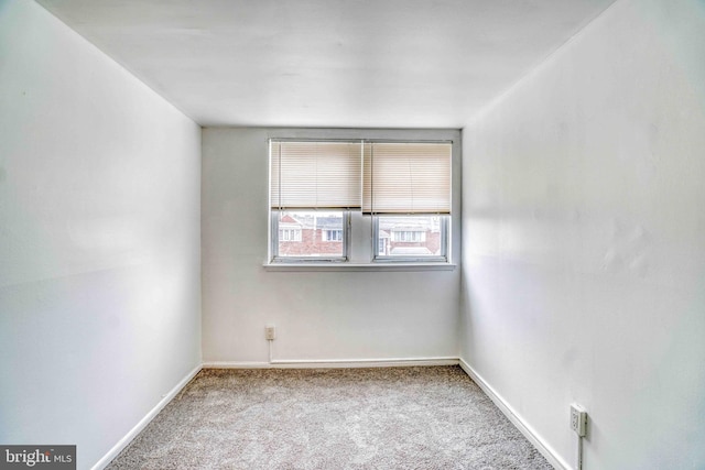 carpeted spare room with baseboards