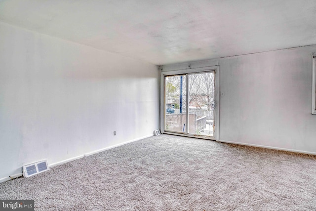 empty room featuring visible vents, baseboards, and carpet floors