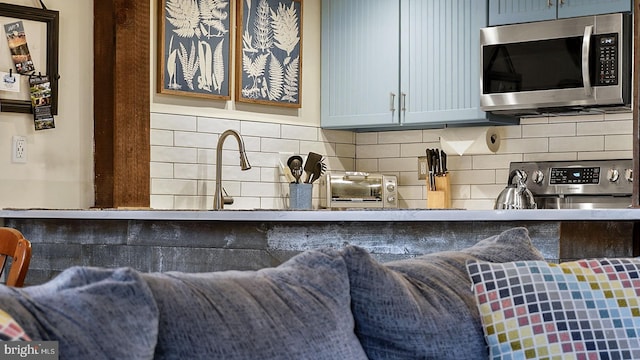 kitchen featuring stainless steel microwave, stove, and decorative backsplash