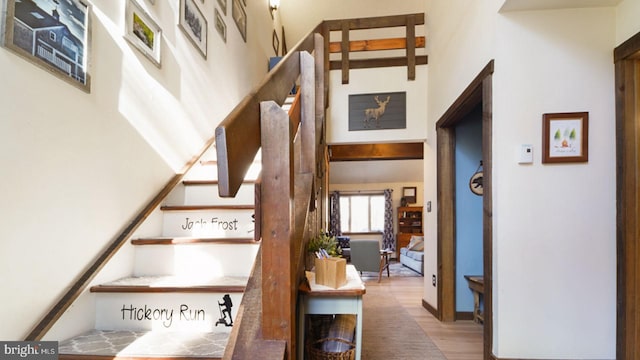 stairs with a high ceiling and wood finished floors