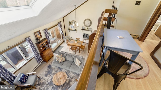 living area with a baseboard heating unit, wood finished floors, and a chandelier